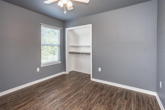 unfurnished bedroom featuring a closet, a ceiling fan, baseboards, and dark wood finished floors