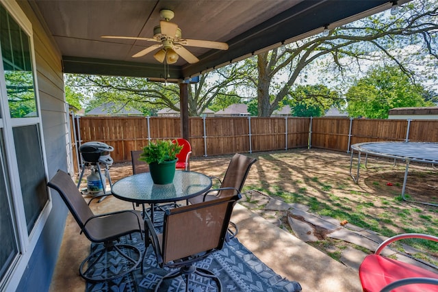 view of patio with area for grilling, a fenced backyard, a ceiling fan, and outdoor dining area