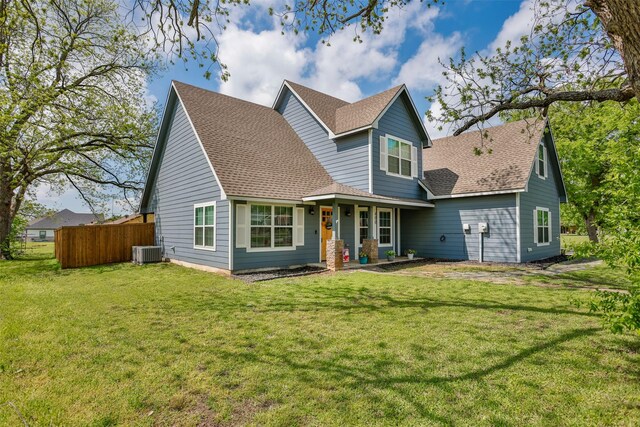 back of house with a lawn, fence, central air condition unit, and a shingled roof