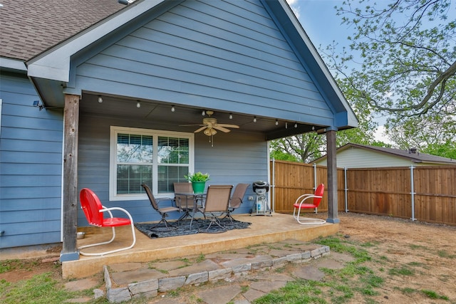 exterior space with a patio, a ceiling fan, outdoor dining space, roof with shingles, and fence
