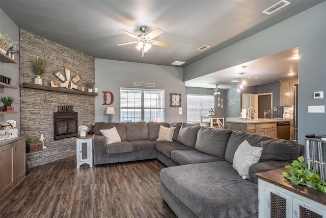 living room featuring a ceiling fan, visible vents, and dark wood-style flooring