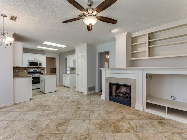 kitchen with stainless steel appliances, ceiling fan, visible vents, white cabinetry, and a textured ceiling