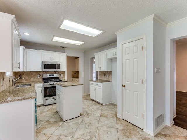 kitchen featuring a sink, tasteful backsplash, visible vents, white cabinets, and appliances with stainless steel finishes