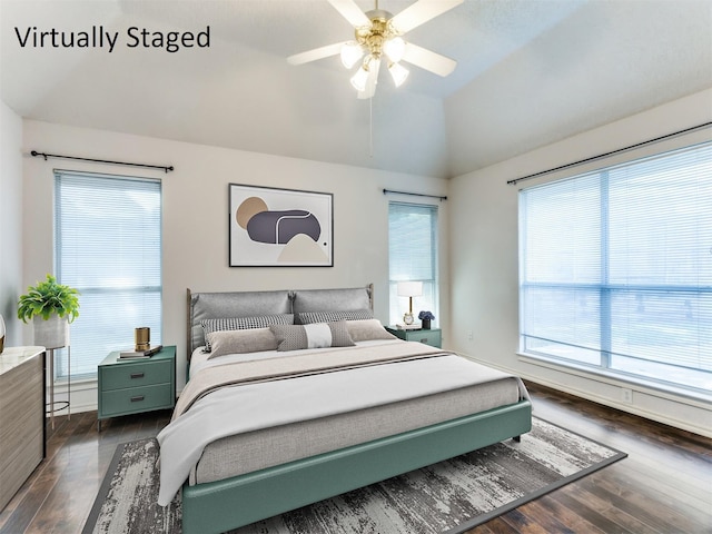 bedroom featuring dark wood-style flooring, multiple windows, and lofted ceiling