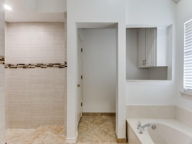 bathroom with tiled shower, tile patterned flooring, and a bath