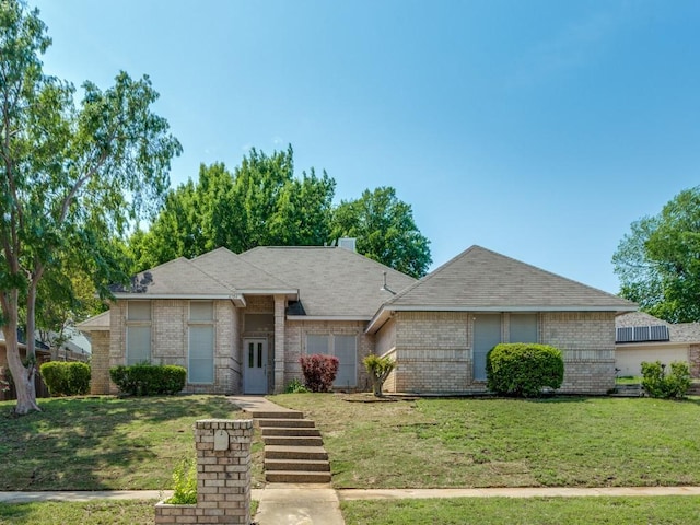single story home featuring brick siding and a front yard