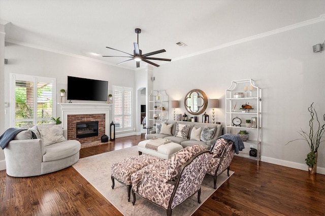 living area with wood finished floors, ceiling fan, baseboards, visible vents, and crown molding