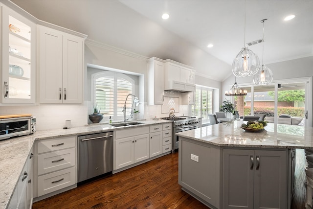 kitchen with white cabinets, a center island, appliances with stainless steel finishes, and a sink