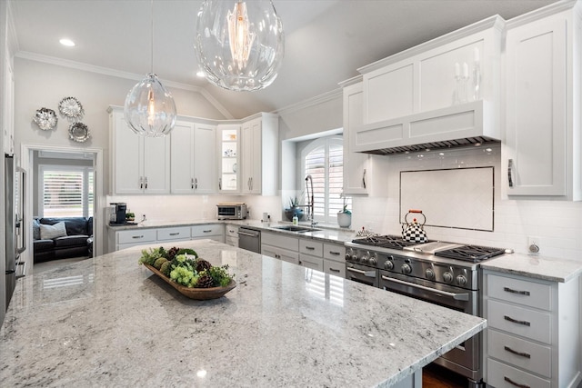 kitchen with white cabinetry, stainless steel appliances, crown molding, and light stone counters