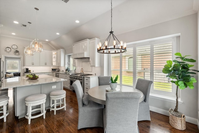 dining area featuring a chandelier, visible vents, lofted ceiling, and crown molding