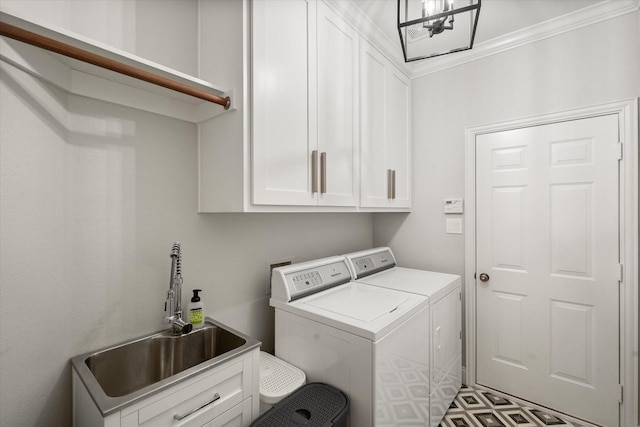 laundry area with cabinet space, washer and clothes dryer, and a sink