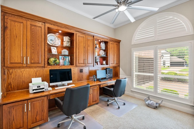 office featuring built in desk, ornamental molding, a ceiling fan, and carpet flooring