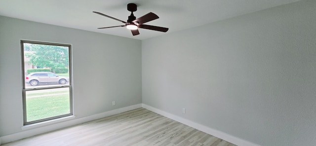 spare room with a ceiling fan, baseboards, a wealth of natural light, and light wood-type flooring