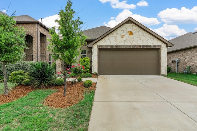 view of front of property featuring a shingled roof, an attached garage, brick siding, stone siding, and concrete driveway