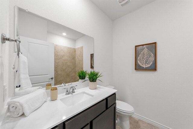 bathroom featuring visible vents, vanity, tile patterned floors, baseboards, and toilet
