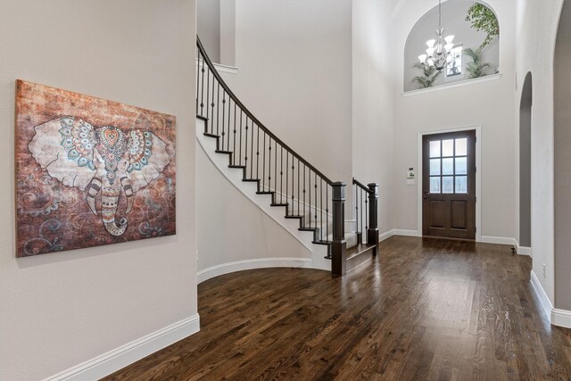 3404 Ophel Way, Flower Mound, TX 75028 - foyer featuring arched walkways, dark wood finished floors, a towering ceiling, and stairway