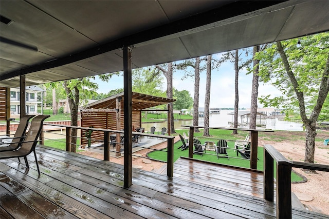 wooden terrace featuring a lawn and a water view