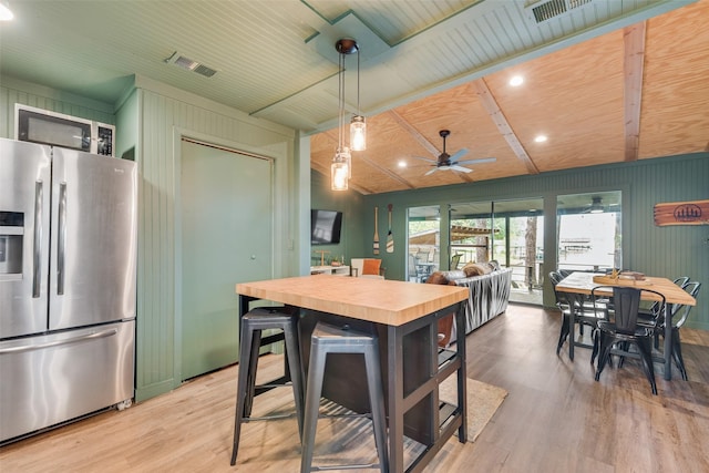 kitchen with a ceiling fan, stainless steel refrigerator with ice dispenser, visible vents, wood finished floors, and wood counters