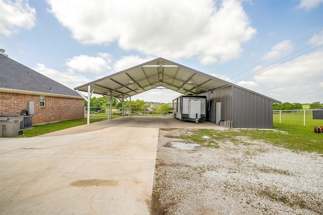 view of parking / parking lot with fence, a carport, and concrete driveway