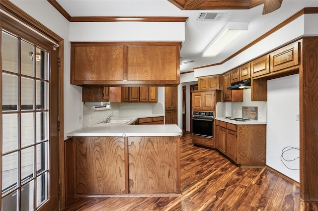kitchen featuring black oven, dark wood-style flooring, and crown molding