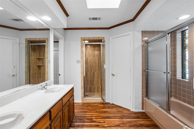 bathroom featuring a sink, crown molding, visible vents, and wood finished floors