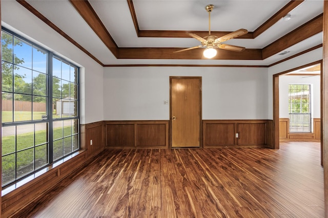 spare room with dark wood-style floors, wainscoting, and a tray ceiling