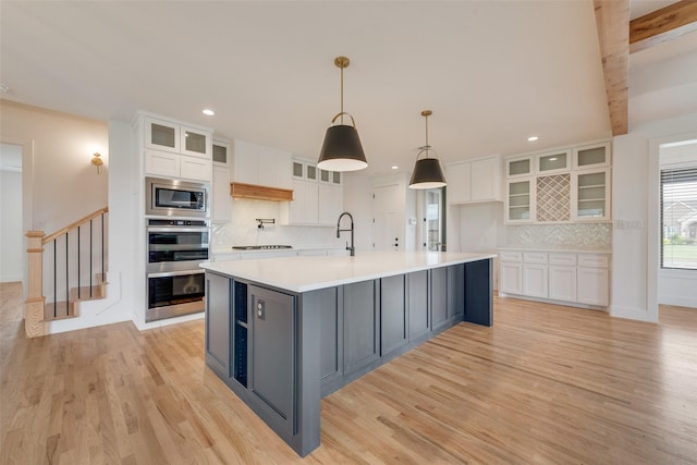 kitchen featuring recessed lighting, white cabinetry, appliances with stainless steel finishes, and light wood-style floors