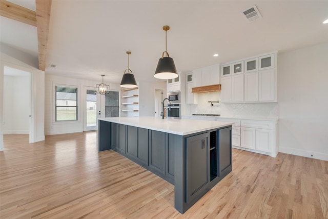 kitchen featuring stainless steel appliances, light wood-type flooring, white cabinetry, and visible vents