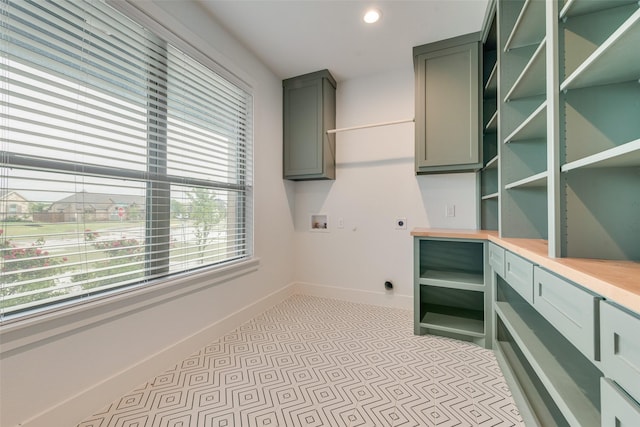 clothes washing area featuring washer hookup, electric dryer hookup, cabinet space, baseboards, and recessed lighting