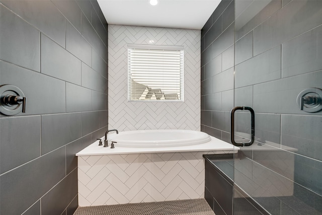 full bathroom with tile walls, tiled shower, and a bath