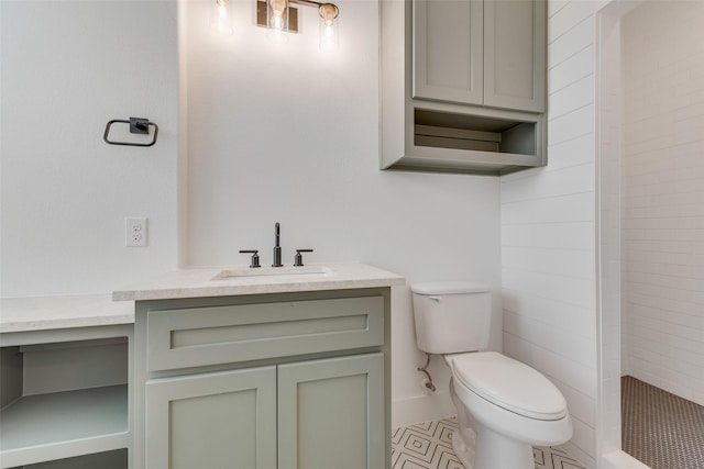 bathroom featuring vanity, a tile shower, and toilet