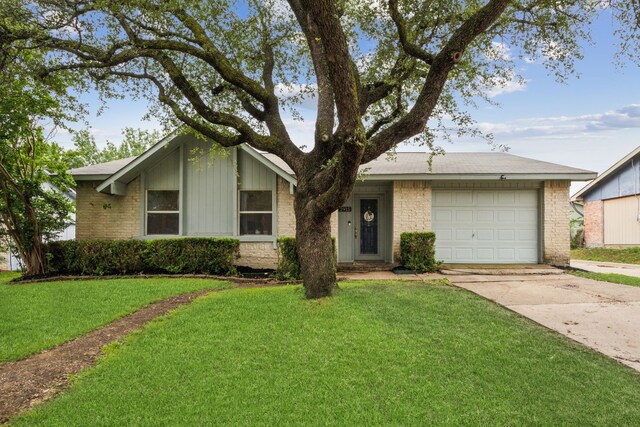 mid-century modern home featuring brick siding, driveway, a front yard, and a garage