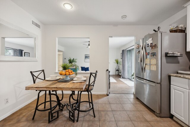 dining area with baseboards, visible vents, and light tile patterned floors