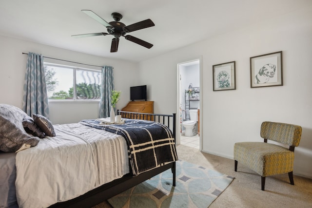 bedroom with ensuite bathroom, a ceiling fan, and light colored carpet