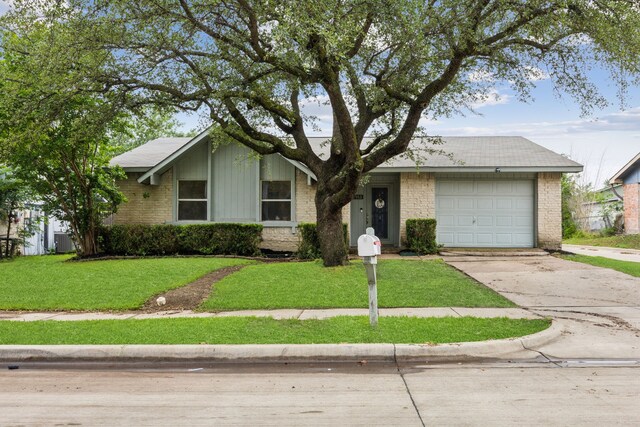 view of front of house featuring concrete driveway, brick siding, a front yard, and a garage