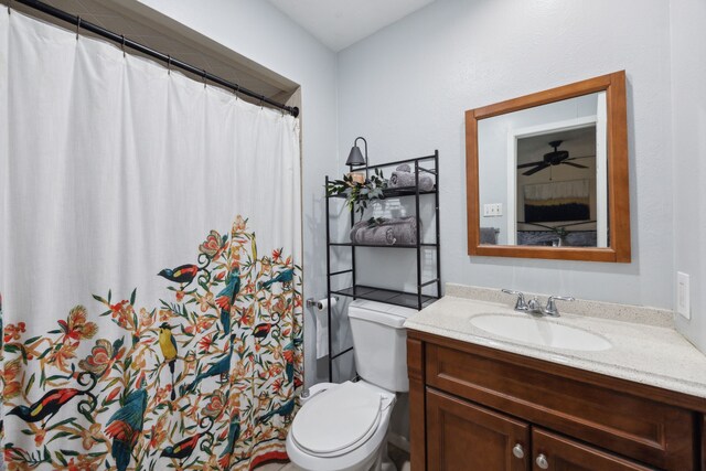 bathroom featuring toilet, a shower with shower curtain, and vanity