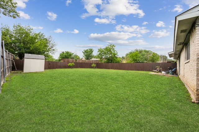 view of yard featuring a fenced backyard, an outdoor structure, and a shed