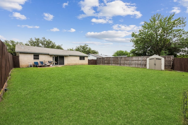 view of yard featuring an outdoor structure, a fenced backyard, and a storage shed