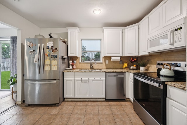 kitchen featuring appliances with stainless steel finishes, a wealth of natural light, a sink, and tasteful backsplash