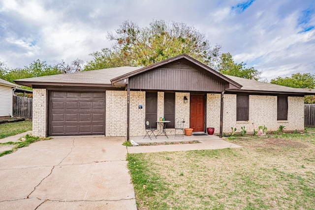 ranch-style house with covered porch, brick siding, driveway, a front yard, and an attached garage