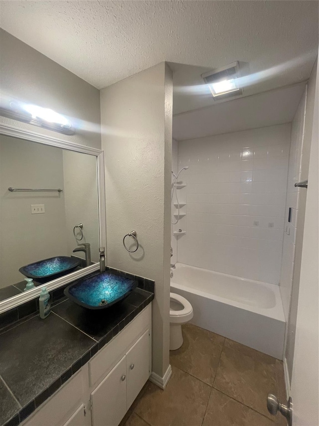 full bath with tile patterned flooring, bathing tub / shower combination, toilet, vanity, and a textured ceiling