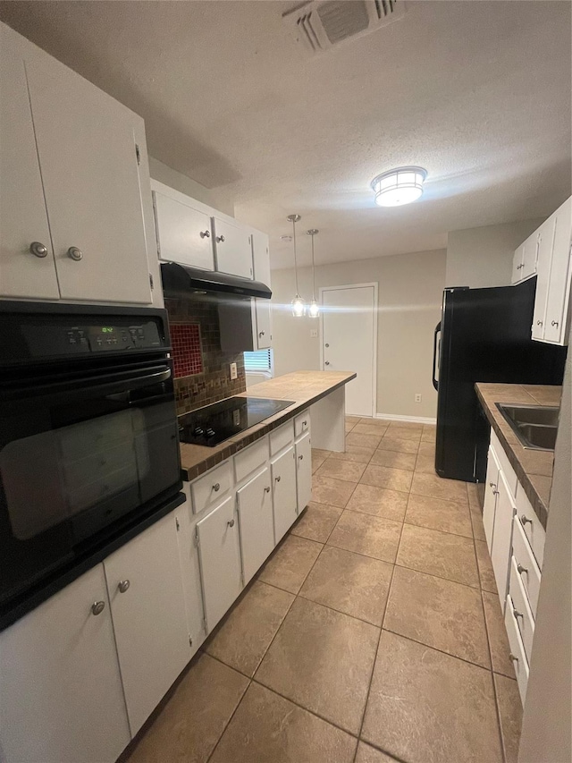 kitchen with a sink, black appliances, visible vents, backsplash, and white cabinetry
