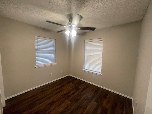 spare room with baseboards, ceiling fan, a textured ceiling, and dark wood-type flooring
