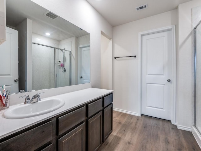 bathroom with visible vents, wood finished floors, and baseboards
