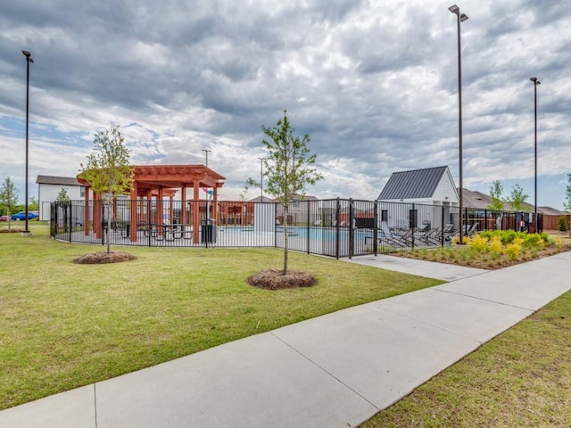 surrounding community featuring fence, a yard, and a swimming pool
