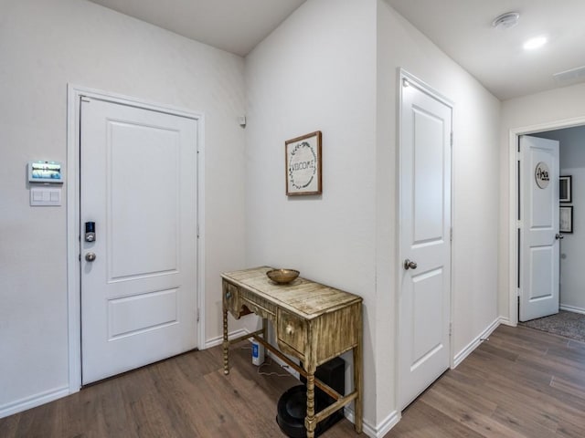 foyer with baseboards and wood finished floors