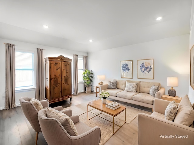 living room featuring a wealth of natural light, light wood-style floors, and baseboards