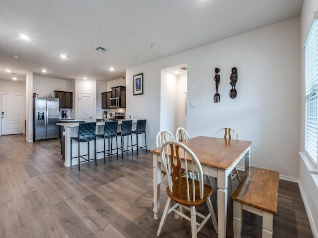 dining area with dark wood-style flooring, visible vents, recessed lighting, and baseboards