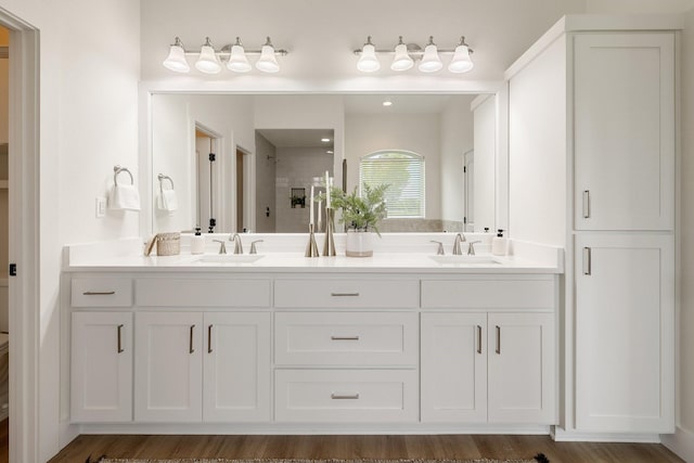 full bathroom featuring a stall shower, double vanity, and a sink