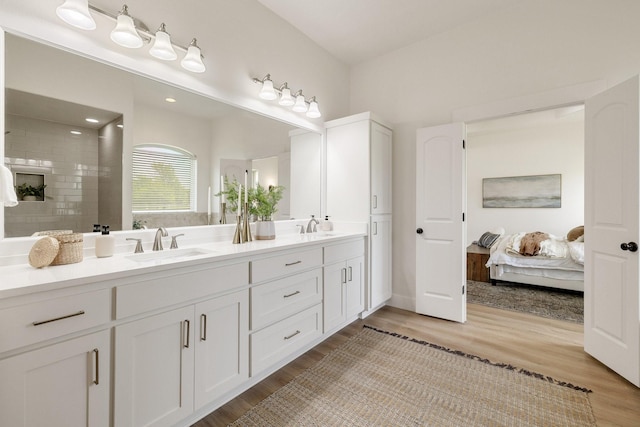 full bath featuring wood finished floors, ensuite bath, and a sink
